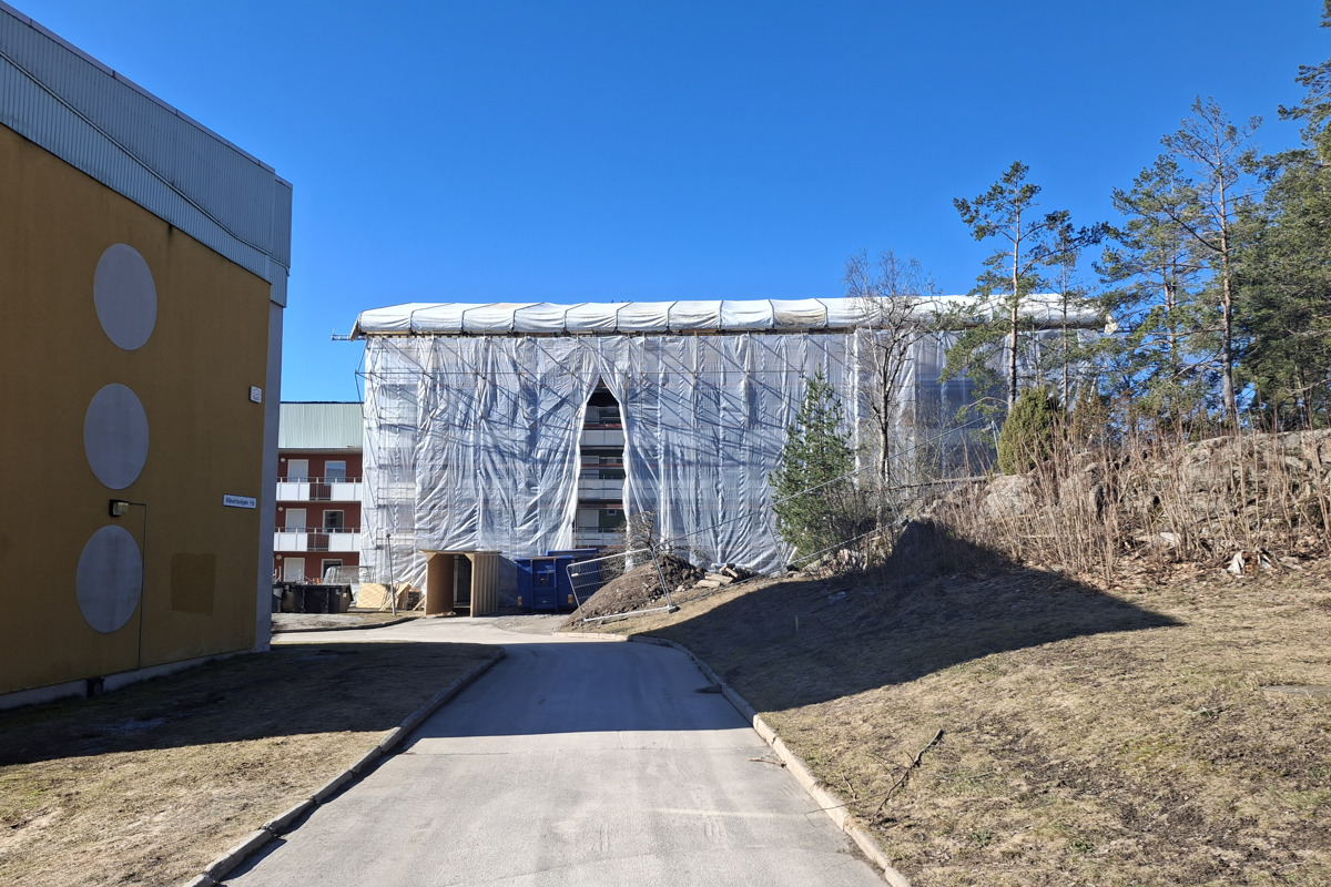 Bilden visar huset på Vänortsvägen 4 inklätt i byggnadsställning under pågående rivning och sanering